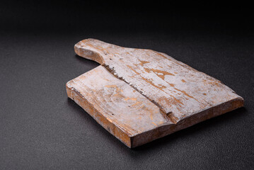 Empty wooden cutting board on dark textured concrete background