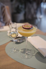 Pornstar martini cocktail with passion fruit , served with sparkling wine in a separate glass on a silver tray
