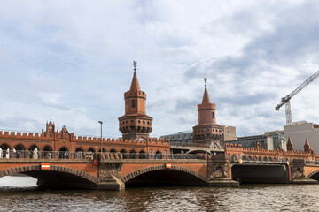 Fototapeta premium Berlin, Germany - April 19, 2024, Oberbaum Bridge - a bridge over the Spree River in Berlin, connecting the districts of Kreuzberg and Friedrichshain, symbolizing the Friedrichshain-Kreuzberg.