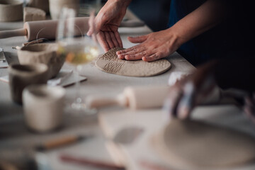Close up of tutor's hands showing earthenware making on pottery class.
