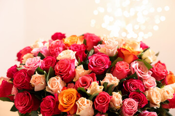 Beautiful bouquet of colorful roses on beige background
