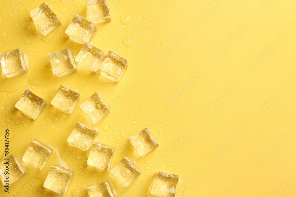 Poster Crystal clear ice cubes on yellow background, flat lay. Space for text