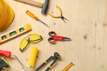 Flat lay composition with building level and other different construction tools on wooden background, space for text