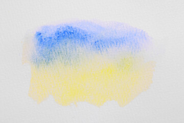 Blot of bright watercolor paints on white paper, top view