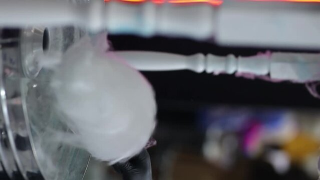 Cotton candy. A man makes cotton candy for children. Manually rolling out cotton candy in a cotton candy machine. Making candy floss