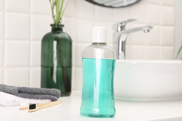 Bottle of mouthwash on white table in bathroom