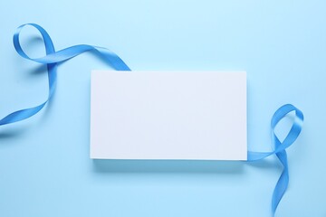 Beautiful bright ribbon and podium on light blue background, flat lay