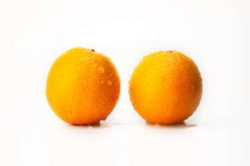 Two oranges are sitting on a white background