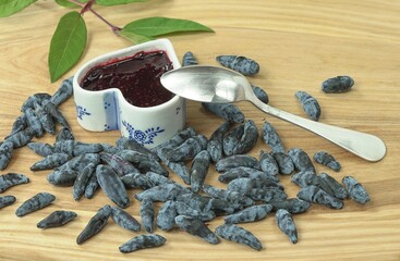 A small porcelain bowl with jam, with a spoon for eating, next to there are many large, natural,...