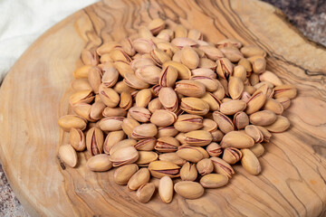 Pile of pistachios on wooden background. Pistacia vera
