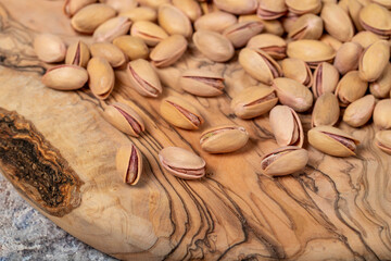 Pile of pistachios on wooden background. Close up