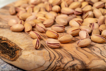 Pile of pistachios on wooden background. Pistacia vera