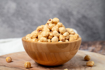 Hazelnuts on wood background. Roasted hazelnuts in a bowl. Close up