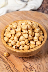 Hazelnuts on wood background. Roasted hazelnuts in a bowl. Close up