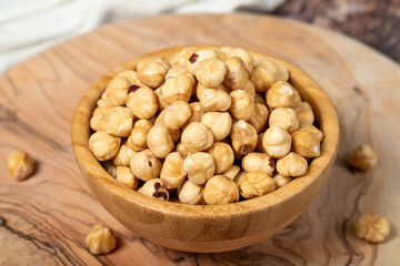 Hazelnuts on wood background. Roasted hazelnuts in a bowl. Close up