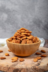 Almonds on wood background. Roasted almonds in a bowl. Close up
