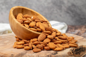 Almonds on wood background. Roasted almonds in a bowl. Close up