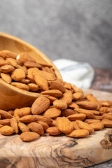 Almonds on wood background. Roasted almonds in a bowl