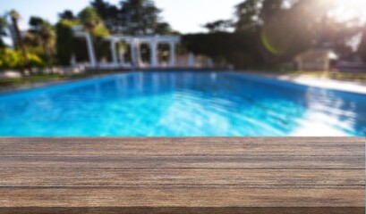 Empty blank wooden table at swimming pool background