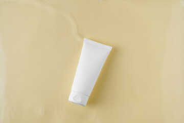 White mockup tube of cream in water on beige isolated background. Concept of skin care, nutrition and hydration, beauty products. Image for your design