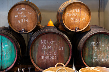 Wooden barrels of traditional Spanish wine on tap in local Catalan store..