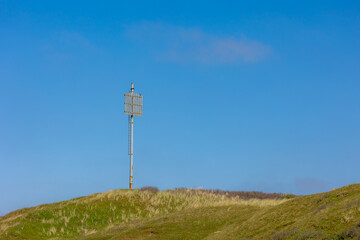 The dunes at Dutch north sea coast, European marram grass (beach grass) under blue sky, Old analog...