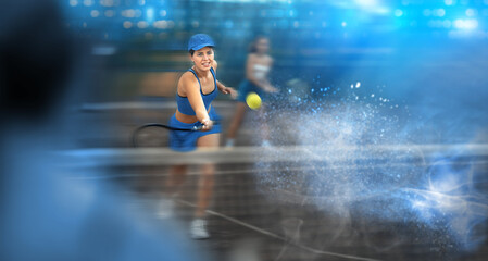 Young sporty woman playing tennis on tennis court blurred background