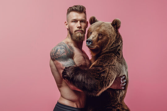 muscular athletic blond man with a beard and tattoos with giant brown bear, soft studio lighting on pink