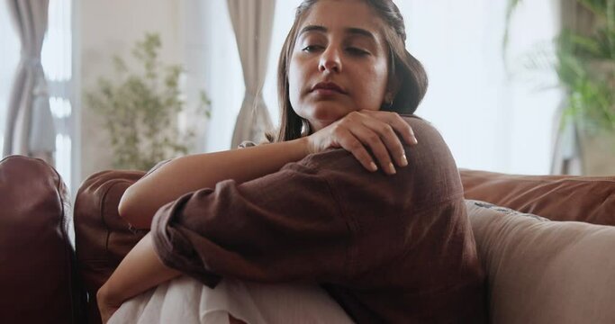 Anxiety, depression and sad woman thinking on sofa with stress, risk or mistake at home. Conflict, fear and girl remember ptsd memory, trauma or domestic violence, crisis or mental health disaster