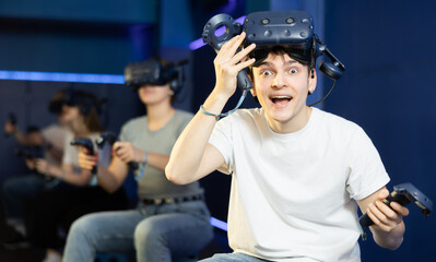 Naklejka premium Surprised young man looking at camera with enthusiastic eyes after playing virtual game