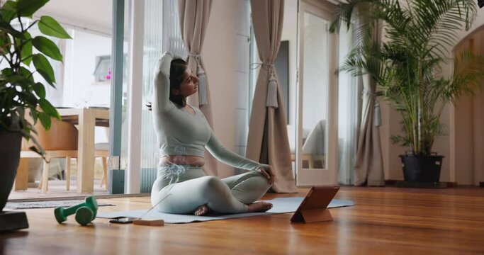 Woman, yoga and stretching with tablet for online class, tutorial or fitness lesson on mat at home. Young female person or yogi in warm up with technology for exercise tips, training steps or workout
