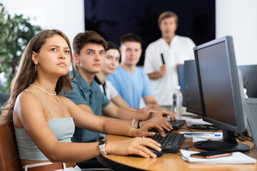In classroom, atmosphere of intense focus prevails as teacher engages students in thought-provoking discussions.