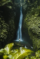 Fototapeten Bali Travel lifestyle. Young traveler man at waterfall in tropical forest. View from back. Leke Leke waterfall, Bali.  © Victoria Nefedova