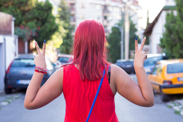 Attractive young redhead woman is showing a peace sign with her fingers