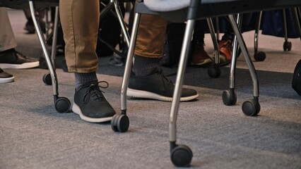 Nervous Impatient Male Employee Fidgeting His Feet during Boring Corporate Presentation Meeting in...