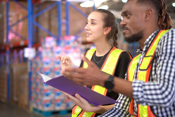 Warehouse staffs discuss and working together.