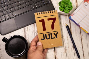 July 17 calendar date text on wooden blocks with blurred background park. Concept