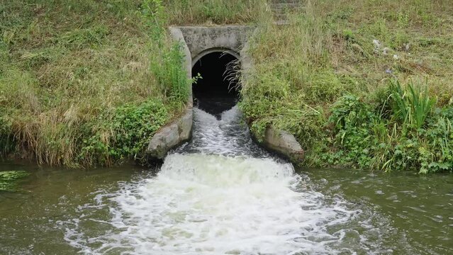 Waste water sewage from a pipe into the river. Water pollution, environment contamination concept