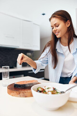 Happy woman cooking healthy food in kitchen, promoting healthy lifestyle and diet concept