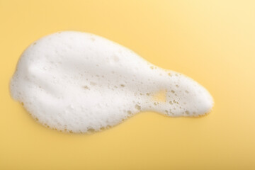 Sample of fluffy foam on yellow background, top view