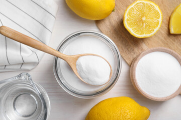 Baking soda, vinegar and lemons on white wooden table, flat lay