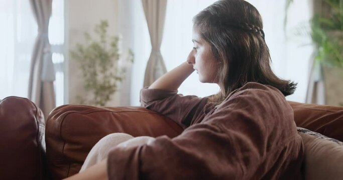 Depression, overthinking and sad woman on sofa with mistake anxiety, regret or mental health crisis at home. Nervous, fail or girl with broken heart in living room with fear, trauma or conflict guilt