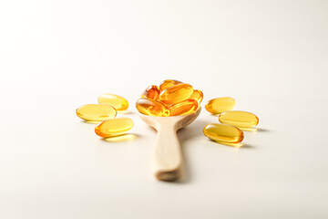 wooden spoon with soft gels, Fish oil capsules, omega 3, omega 9, vitamin D, vitamin E