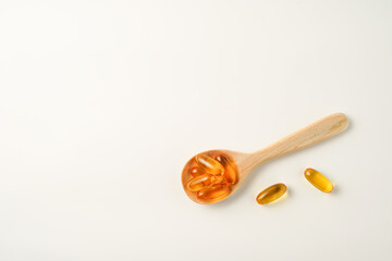 wooden spoon with soft gels, Fish oil capsules, omega 3, omega 9, vitamin D, vitamin E