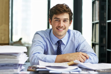 Fototapeta premium Portrait of young businessman in shirt, man smiling and looking at camera at workplace inside office, accountant with calculator behind paper work signing contracts and financial reports 