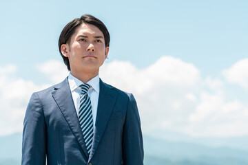 青空の中の若いアジア人ビジネスマン(弁護士,税理士,会計士,行政書士,銀行員,公務員)