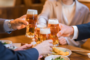 居酒屋・飲み屋で乾杯する男女のサラリーマン
