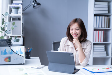 A professional headshot of a female executive, seated at her desk and exuding contentment in her corporate environment.