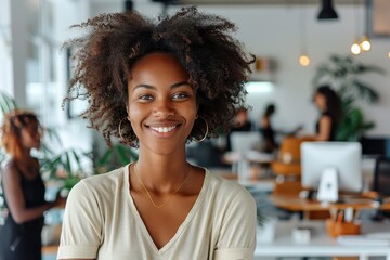 Fototapeta premium A radiant woman with curly hair exudes charm and confidence in a sunlit, plant-filled office