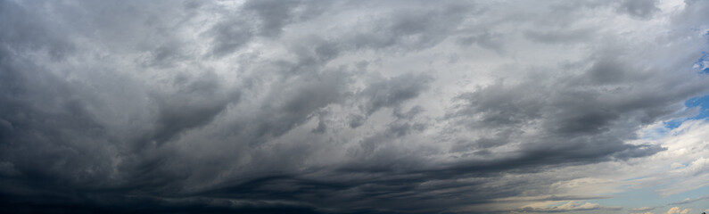 A panoramic view of a gloomy sky full of storm clouds. Only the sky is included in the image.

